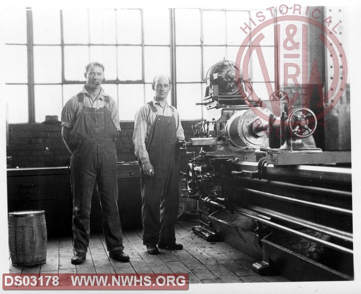 Two men with lathe.
