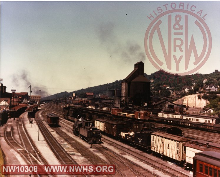 N&W yard scene at Bluefield WV looking west. Station platforms on left. Damage hoppers in yard with portion of wreck train visible.