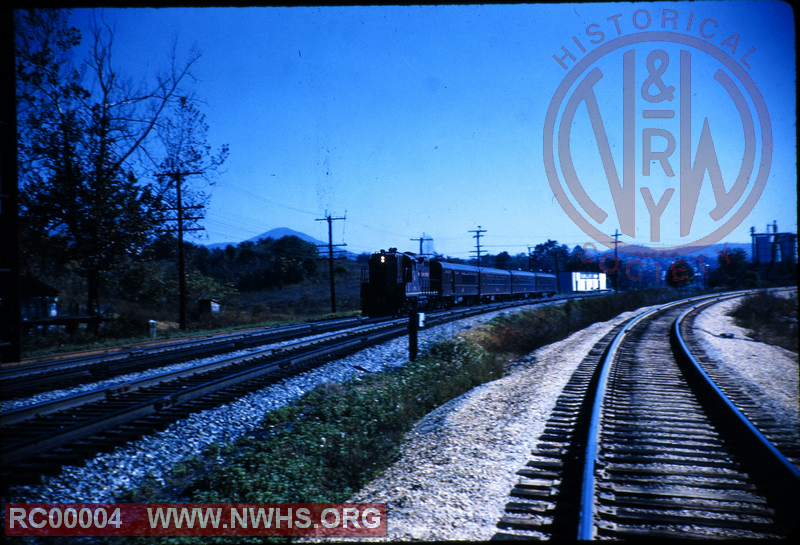 Westbound passenger train passing Tinker Creek Connection in foreground.